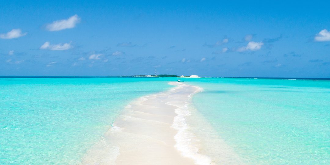 Narrow tip of a Bahamian island surrounded by clear turquoise water