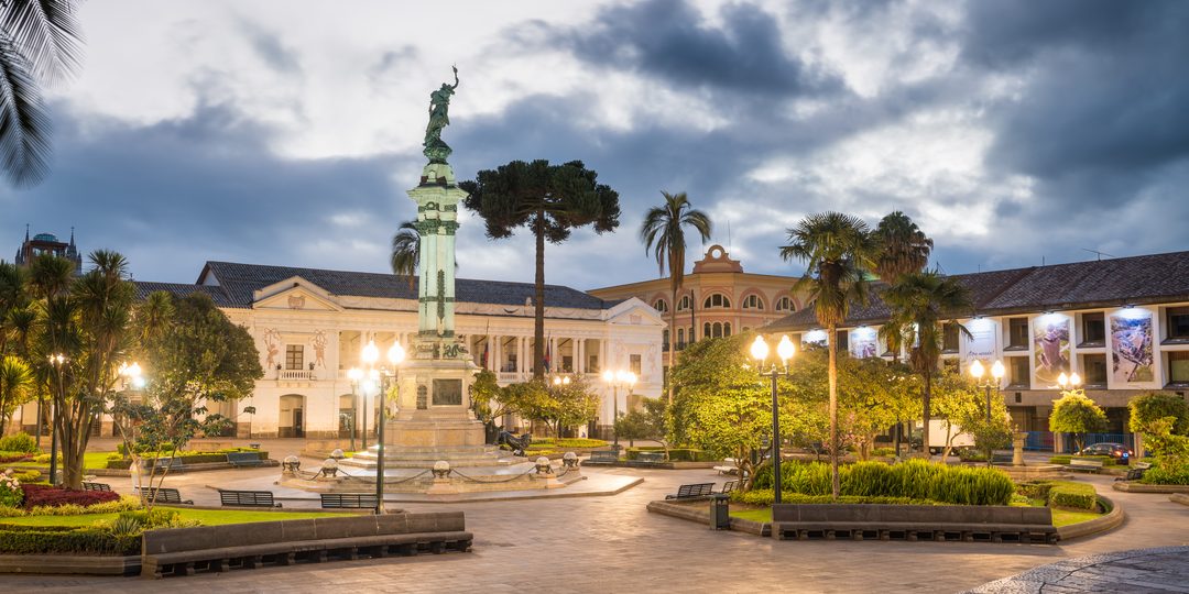 Plaza Grande in Quito's historic center, lit at dusk with a central monument