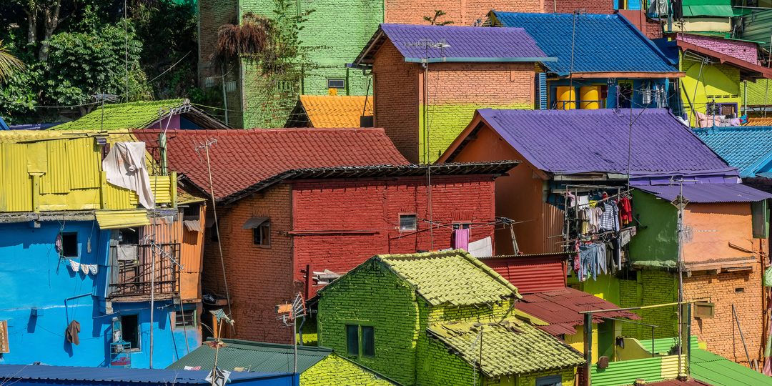 Aerial view of brightly painted hillside houses with corrugated metal roofs