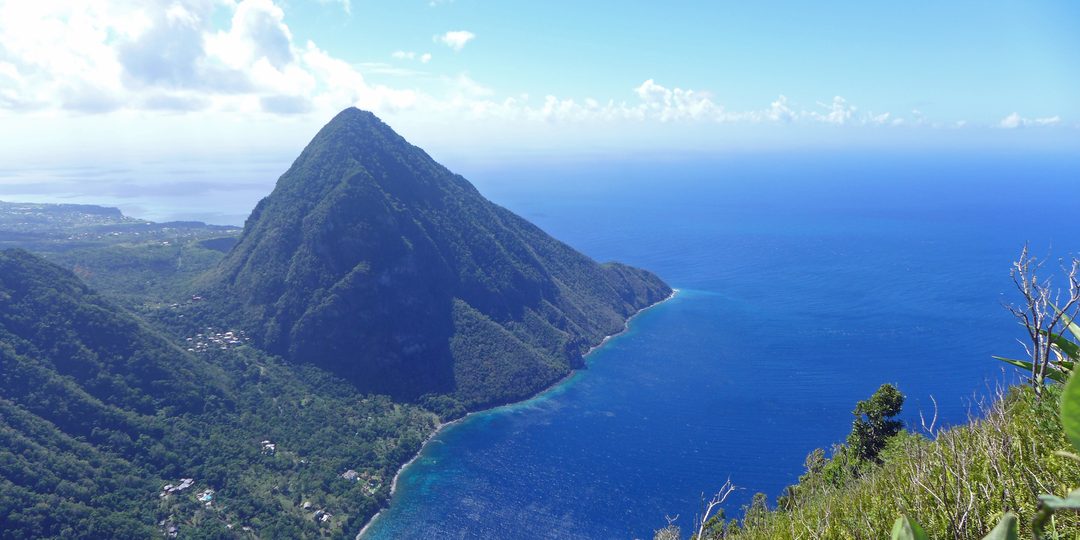 Volcanic twin peaks rising above a Caribbean coastline