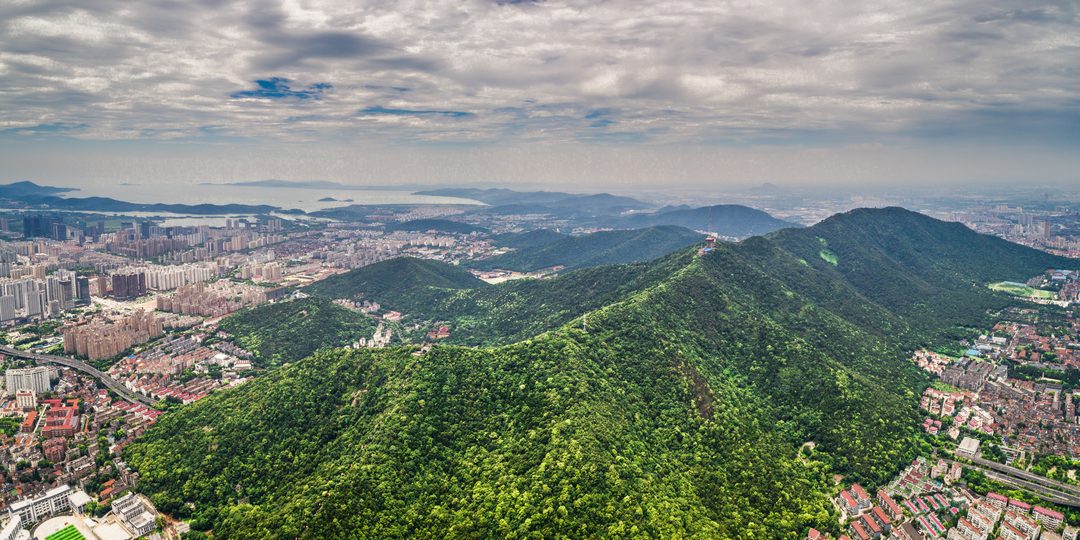 Aerial view of a city nestled among green mountains