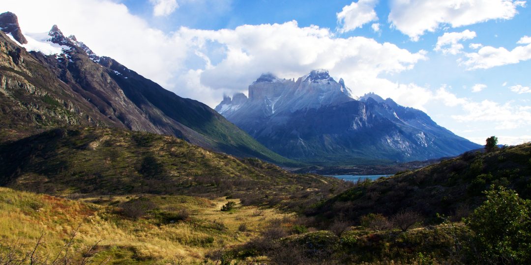The granite peaks of Torres del Paine rising above a green valley in Chilean Patagonia.